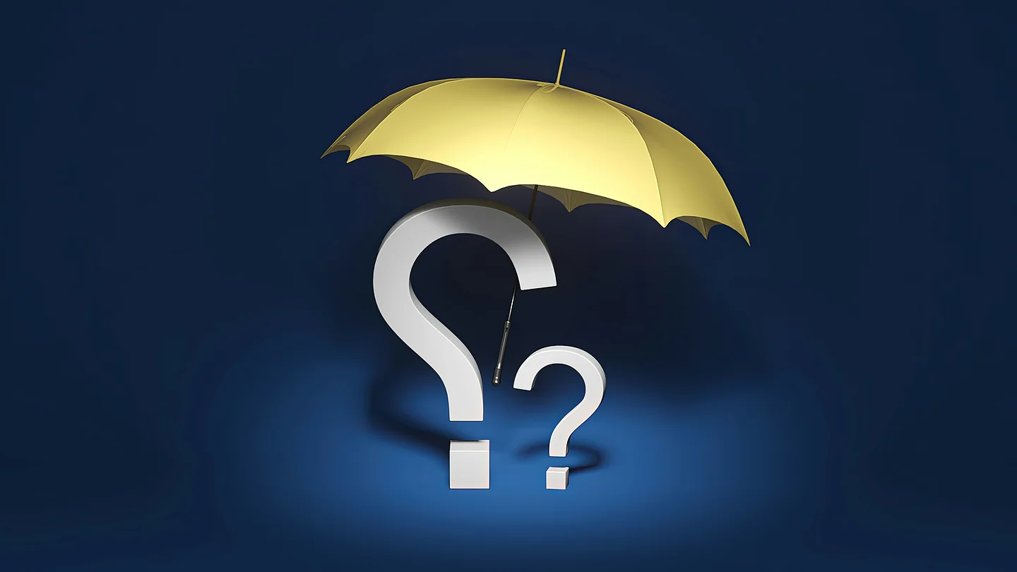 Gelber Regenschirm ueber einem Fragezeichen