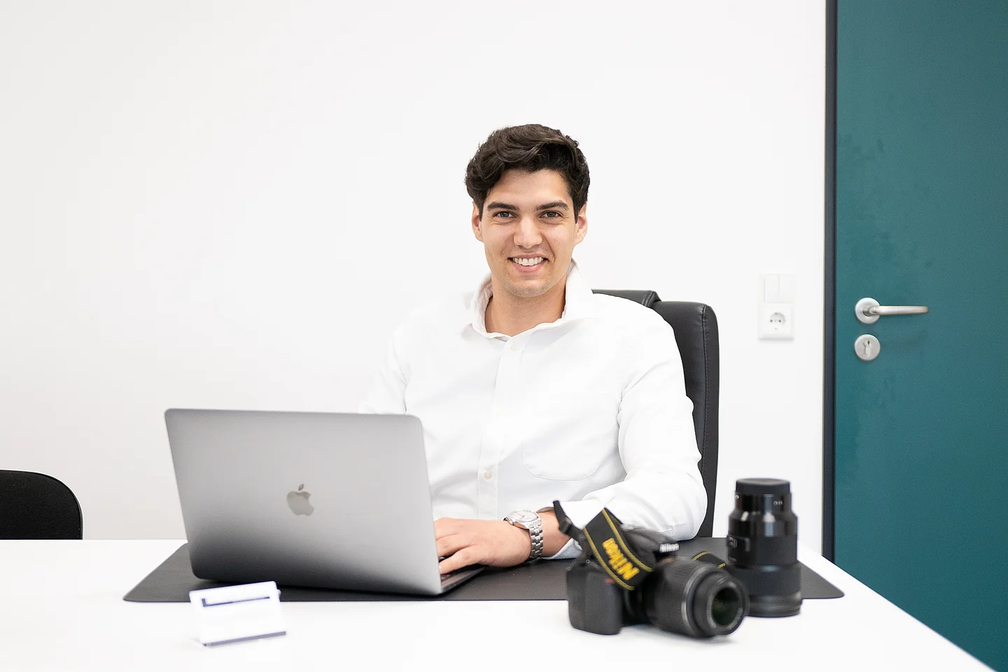 Davide Balsamello am Büro-Schreibtisch vor dem Laptop, rechts die Kameras