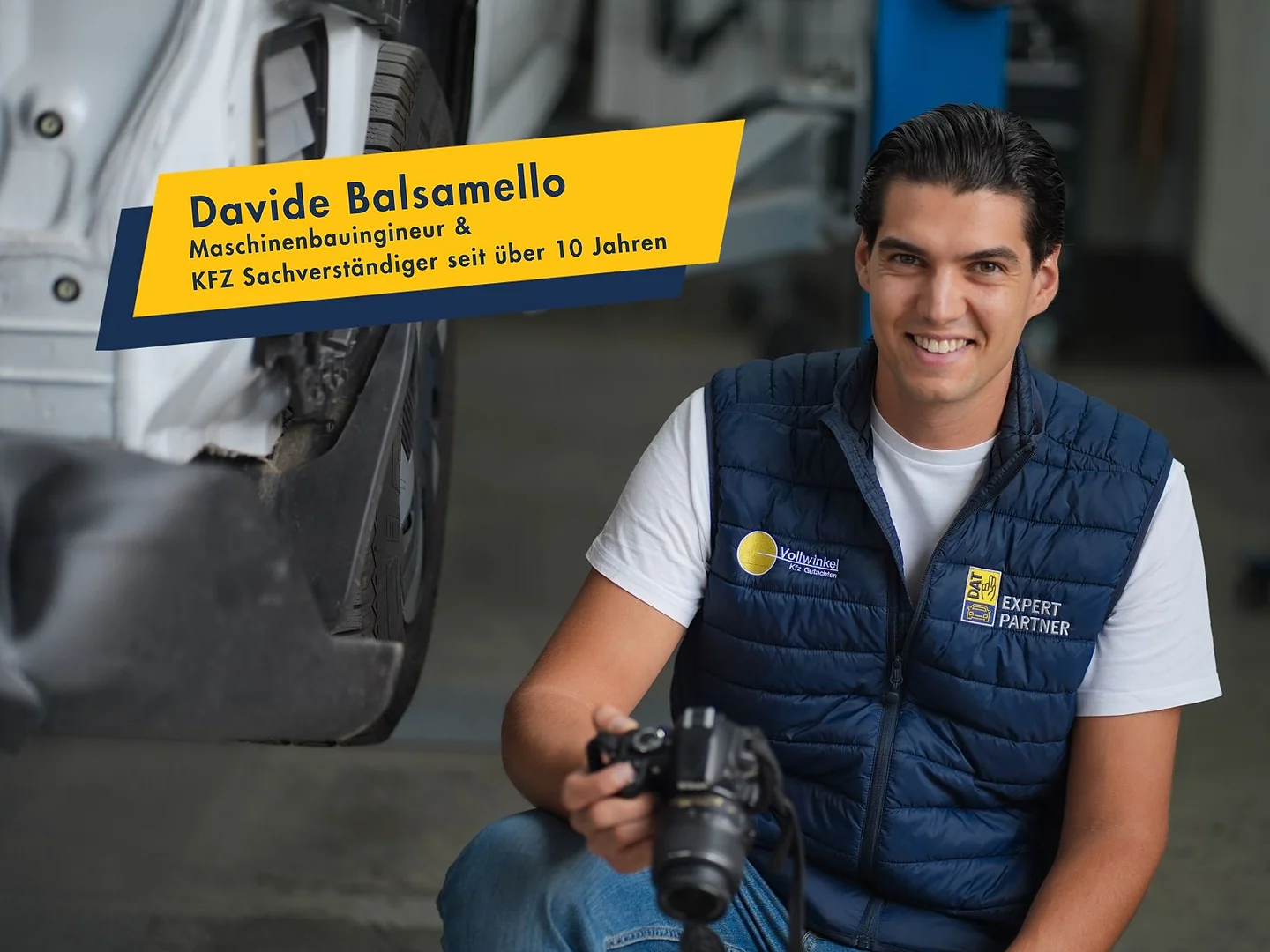 Davide Balsamello mit Kamera in der Werkstatt, im Bild sein Name und seine Qualifikation