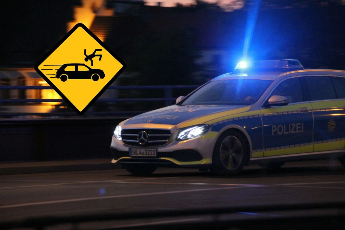 Polizeifahrzeug mit Blaulicht am Abend, daneben ein gelbes Warnschild mit Unfallsymbol